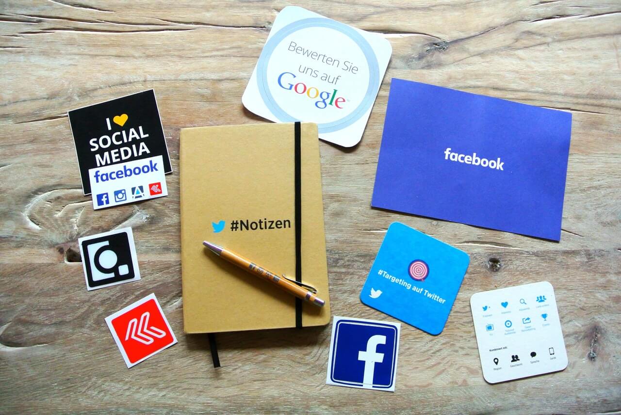 Social media flyers on desk with notebook in the middle